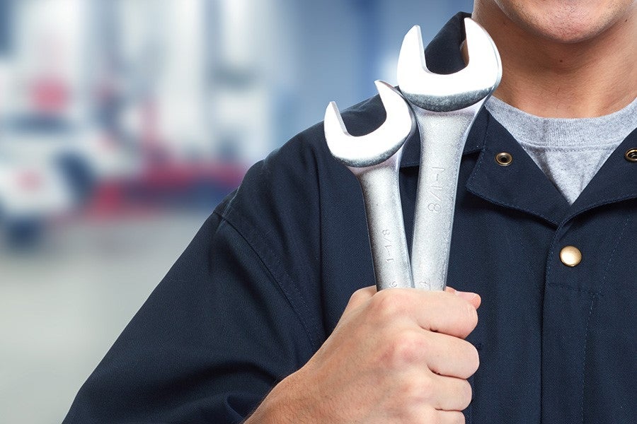 technician holding wrench